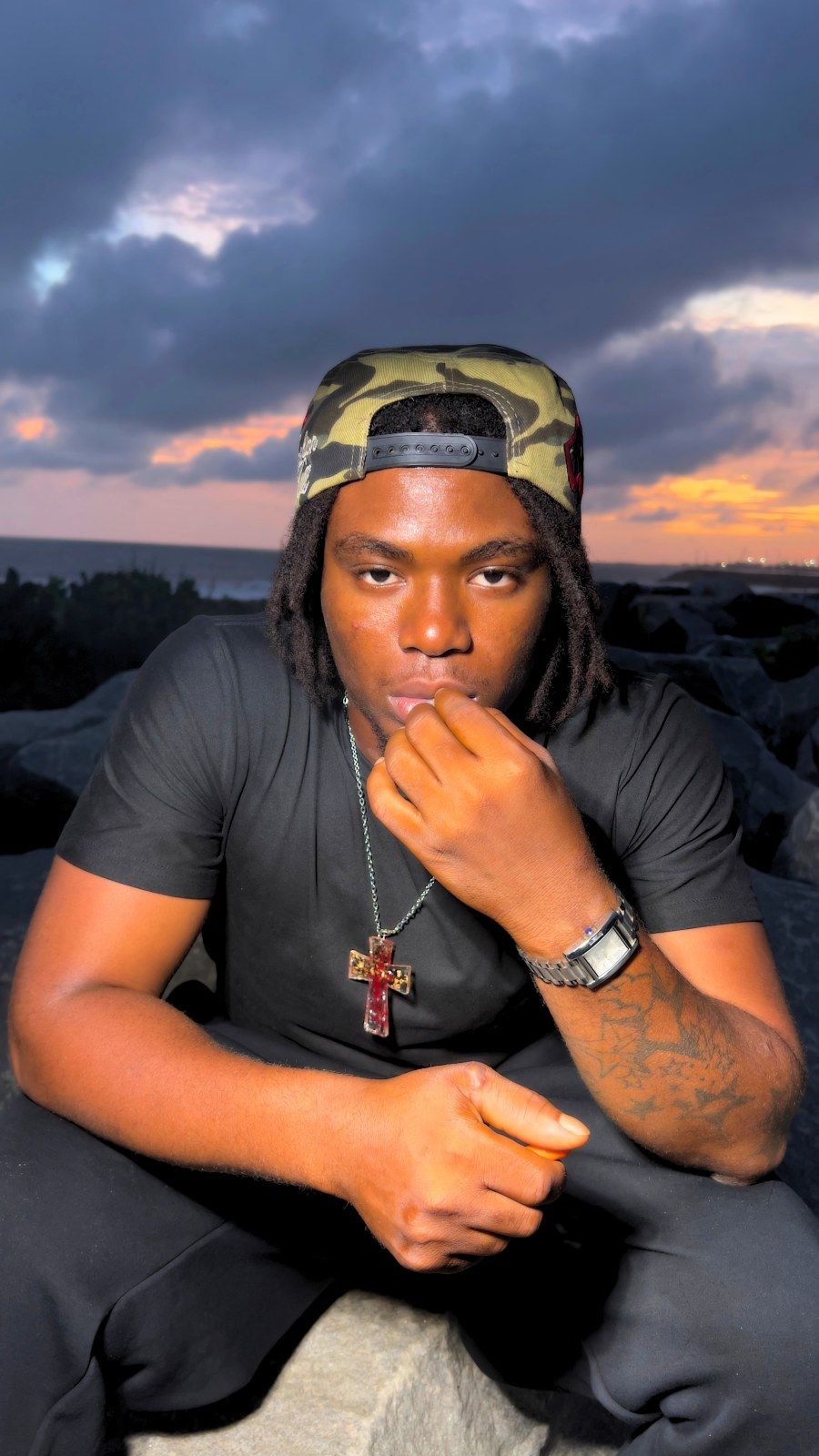 OIM THUG, la main au menton, regard droit
