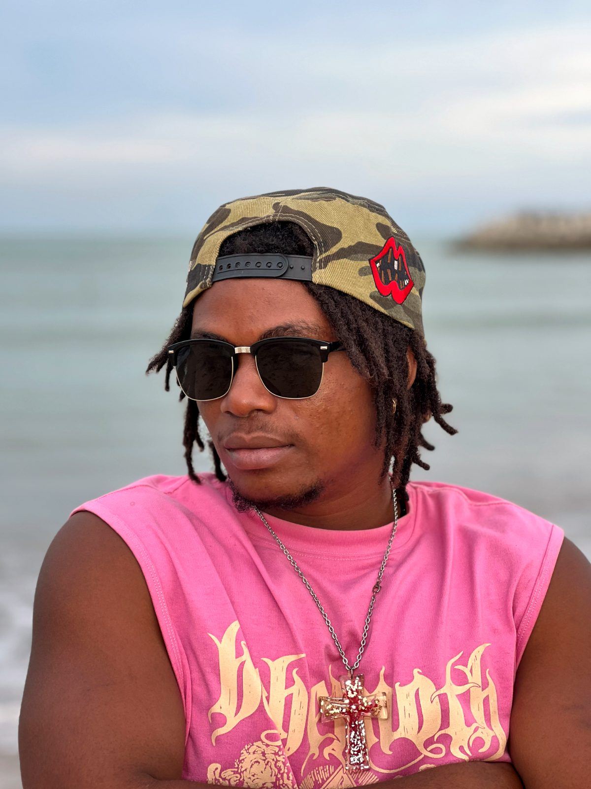 OIM THUG, débardeur rose et casquette camouflage